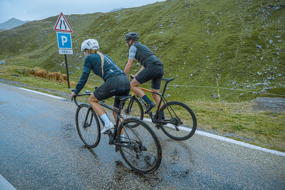 a couple of people riding bikes down a road