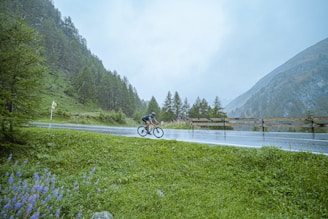 A cyclist riding through a lush green landscape in Ecuador.