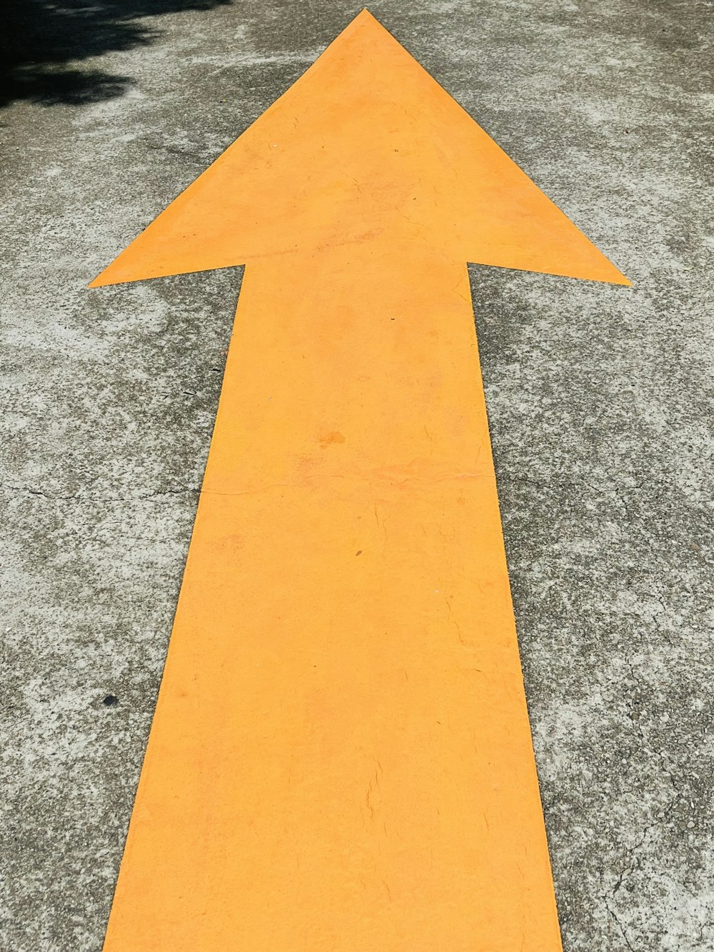 a yellow arrow painted on the ground in a parking lot