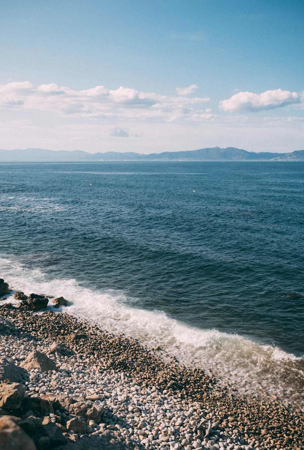 a rocky beach next to a body of water