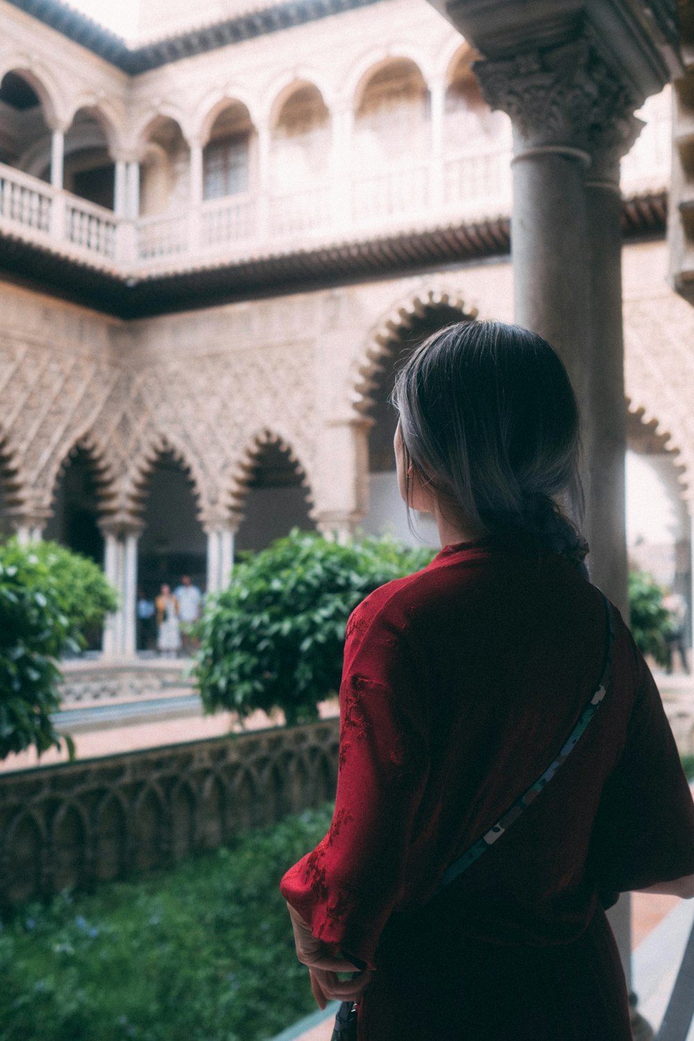 a woman in a red dress looking out a window