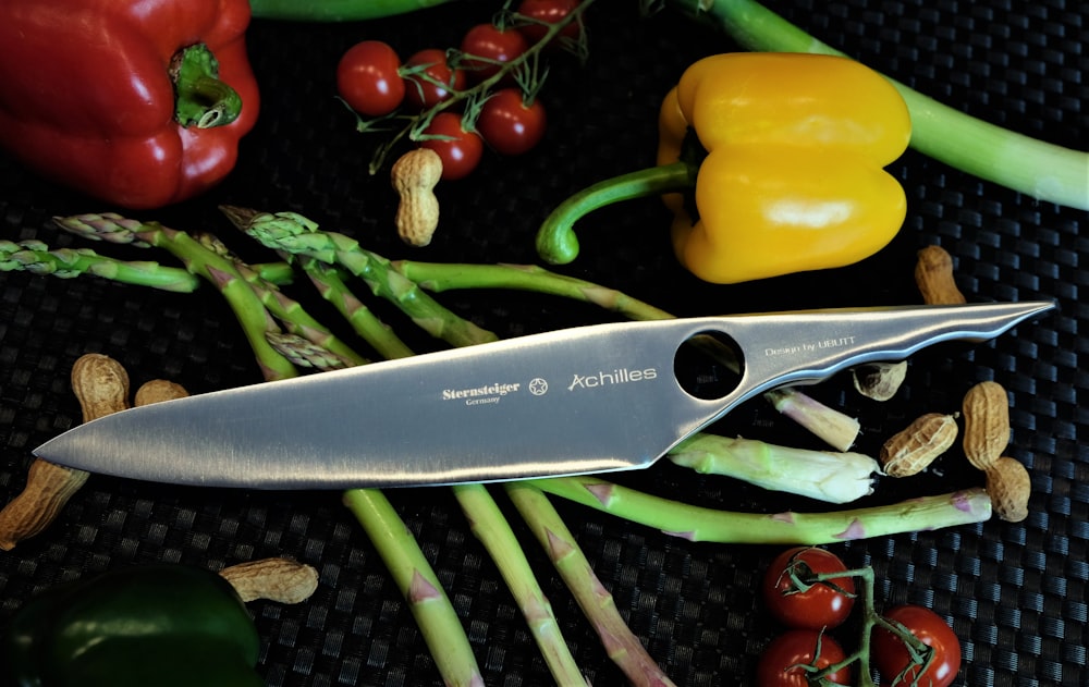 a knife sitting on top of a pile of vegetables