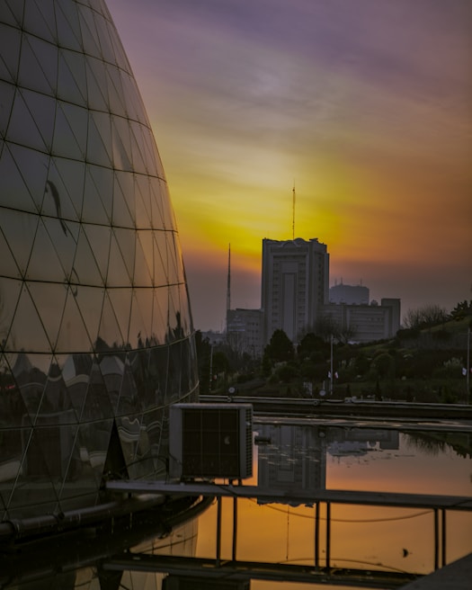 Close-up of a commercial complex’s glass facade reflecting the sunset.