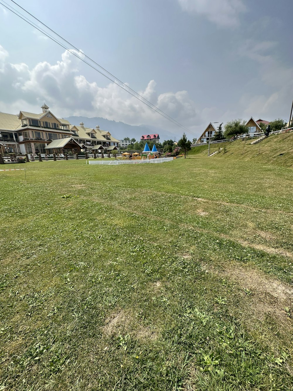 a grassy field with houses in the background