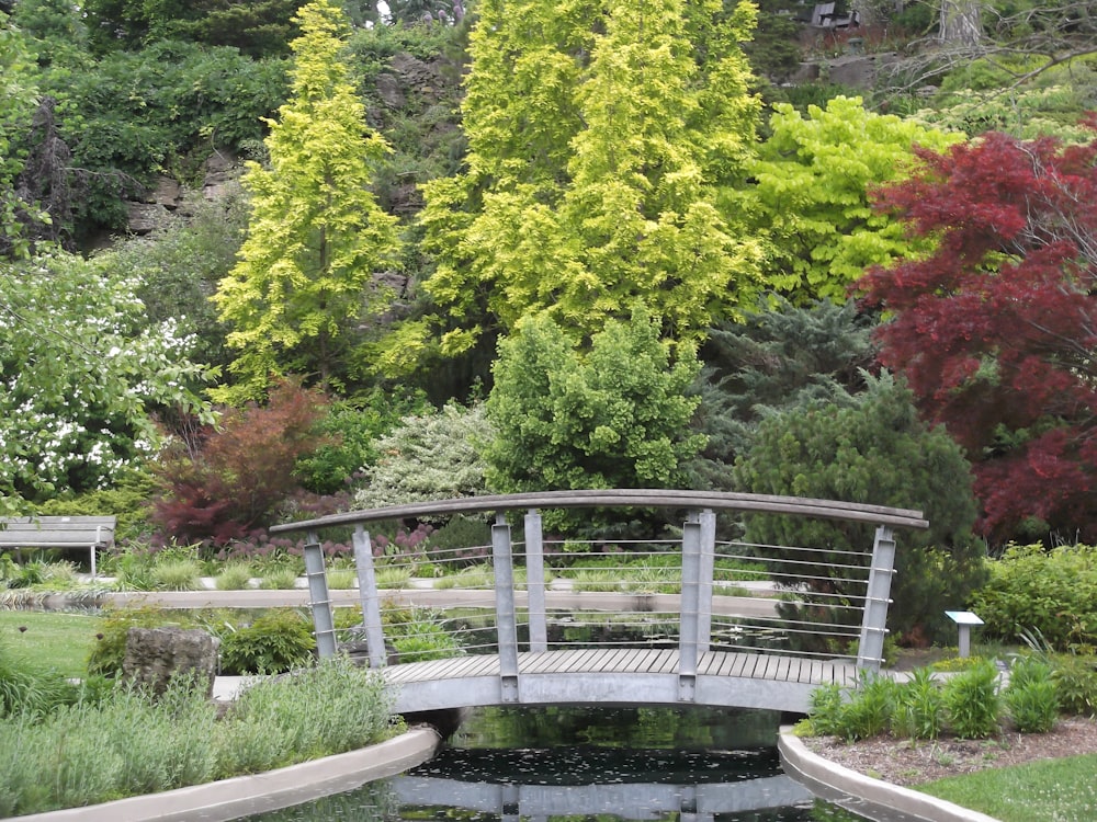 a wooden bridge over a small pond in a park