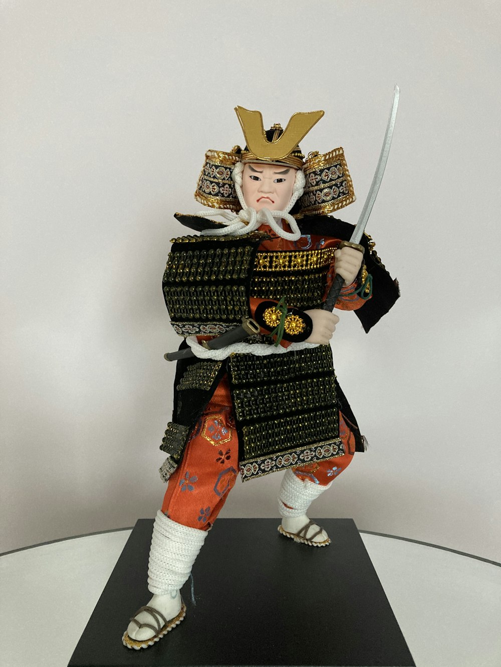 eine Figur eines als Samurai verkleideten Mannes, der ein Schwert hält