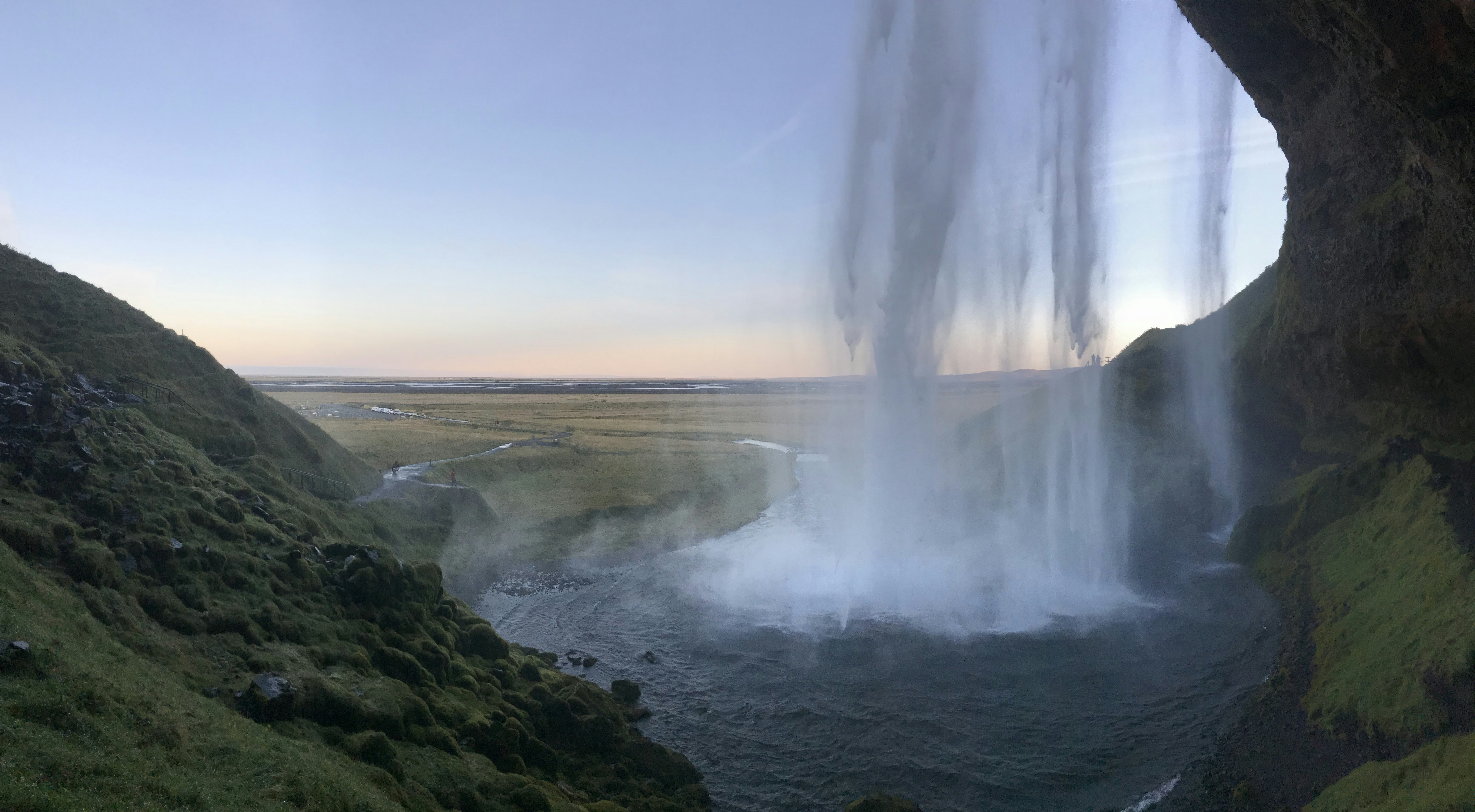 a view of a waterfall from inside a cave