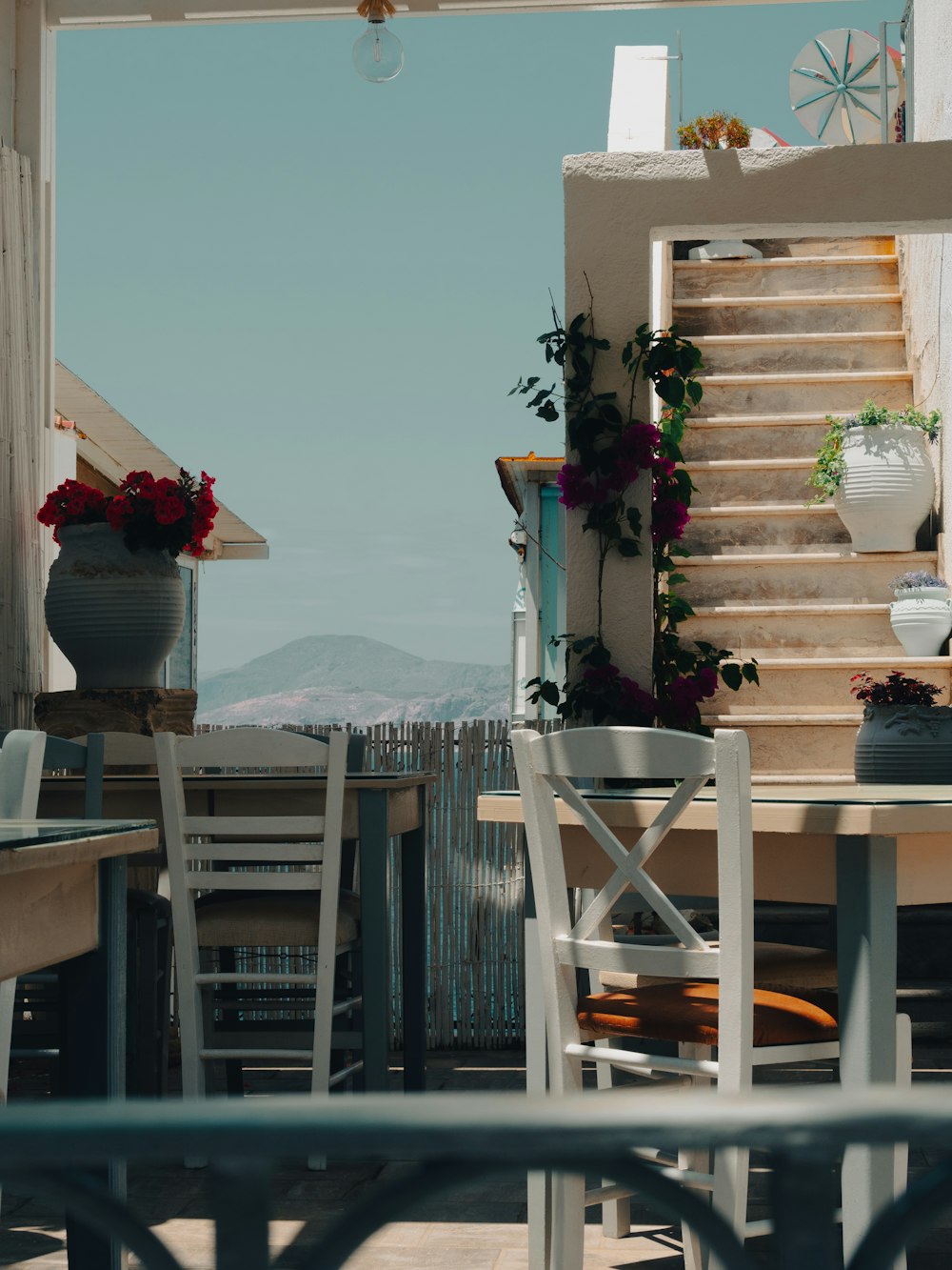 a balcony with a table and chairs with a view of the ocean