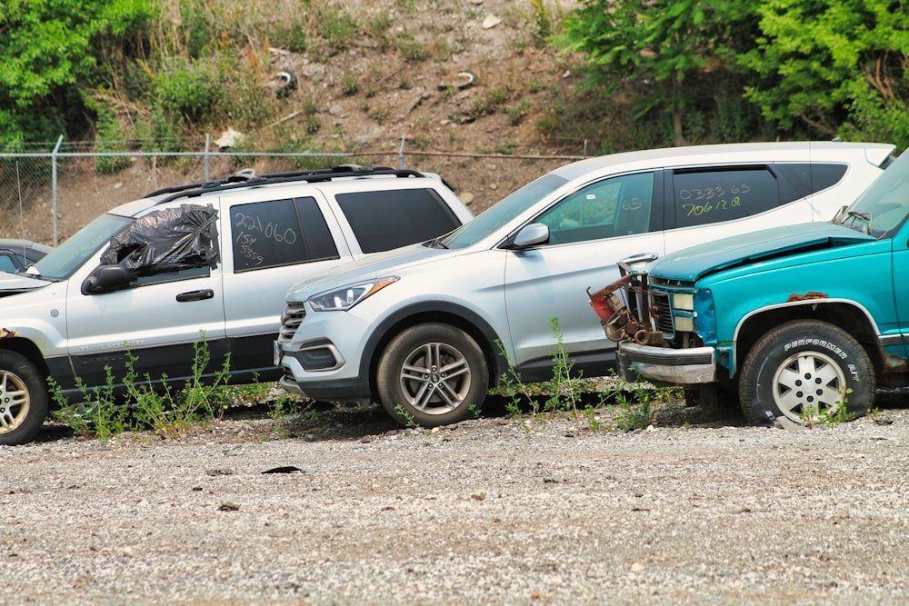 Un par de coches que están aparcados en la tierra