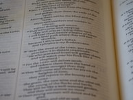 An open book with text printed in two columns. The text appears to be in a poetic format with indented lines and is focused on a religious or spiritual theme. The pages show chapter and verse numbers, indicating scriptural content.