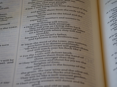 An open book with text printed in two columns. The text appears to be in a poetic format with indented lines and is focused on a religious or spiritual theme. The pages show chapter and verse numbers, indicating scriptural content.