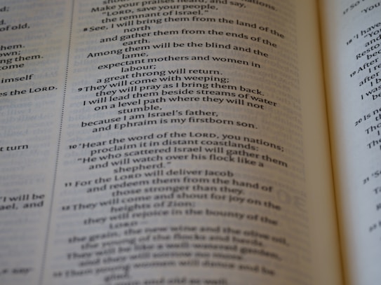 An open book with text printed in two columns. The text appears to be in a poetic format with indented lines and is focused on a religious or spiritual theme. The pages show chapter and verse numbers, indicating scriptural content.