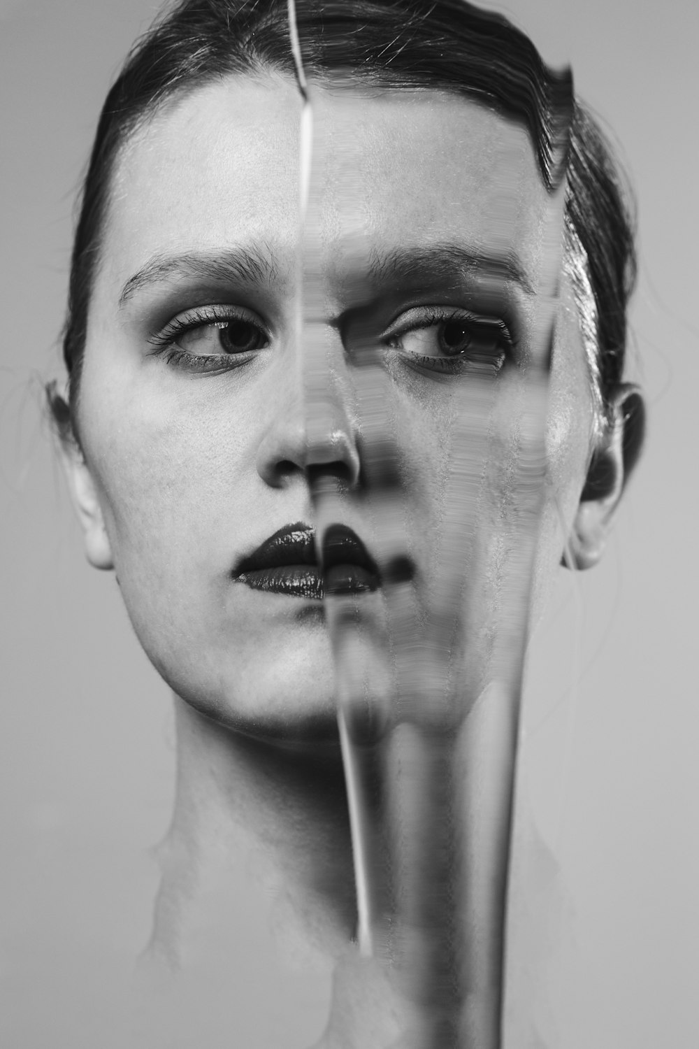 a woman's face is shown through a broken glass