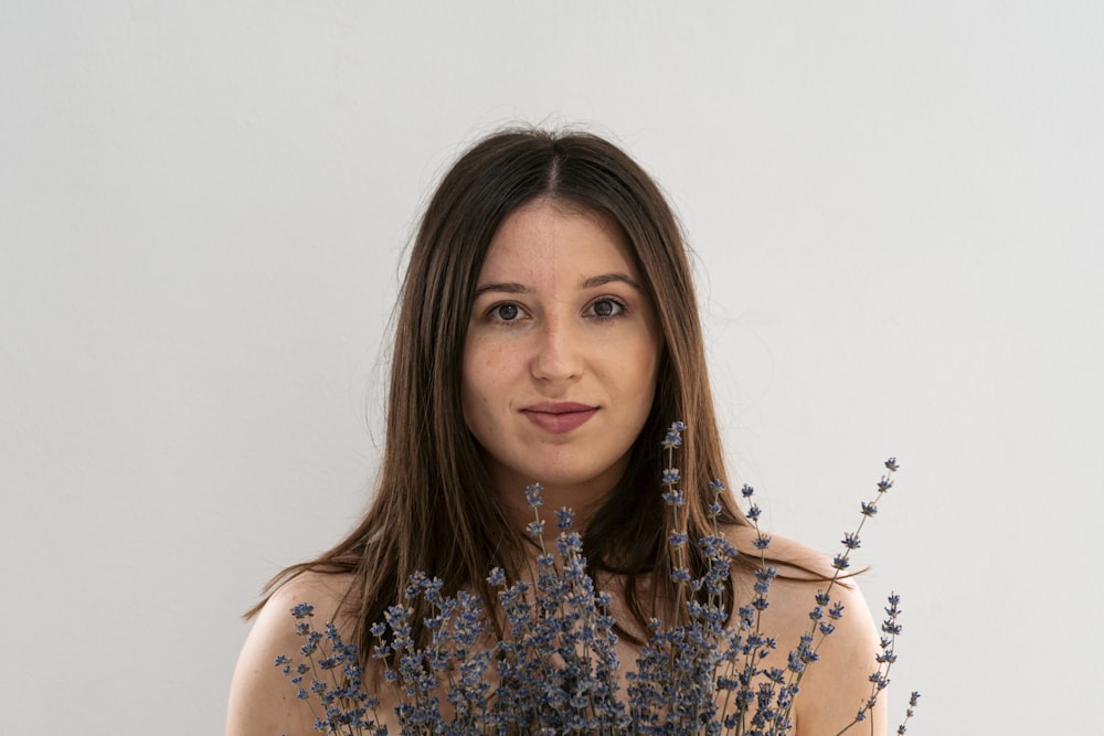 a woman holding a bunch of flowers in front of her face