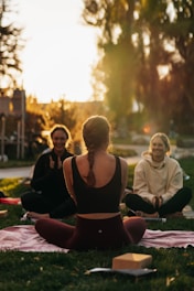 a group of people sitting on top of a lush green field