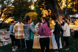 a group of people standing around a table