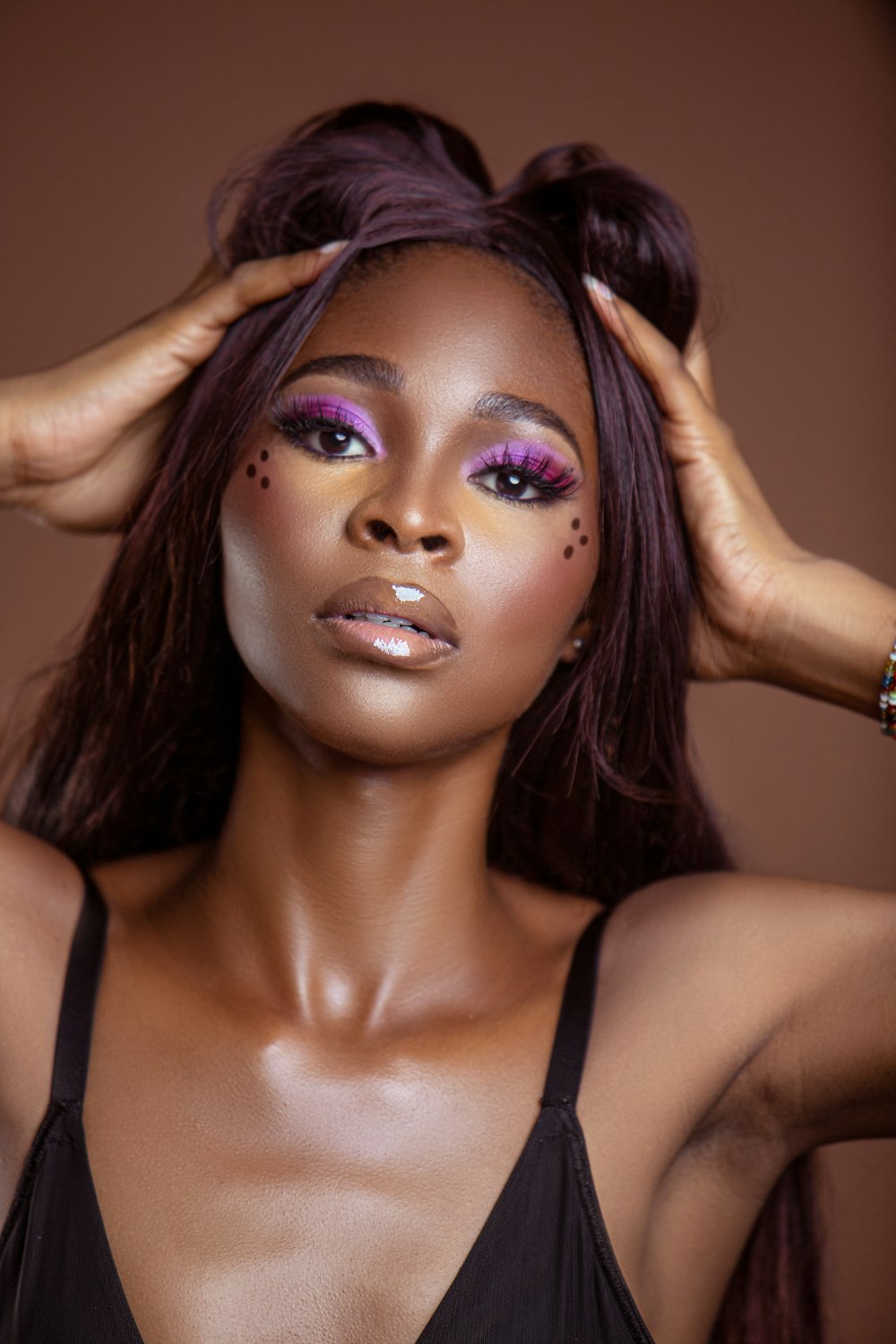 a woman with purple eyeshades and a black top