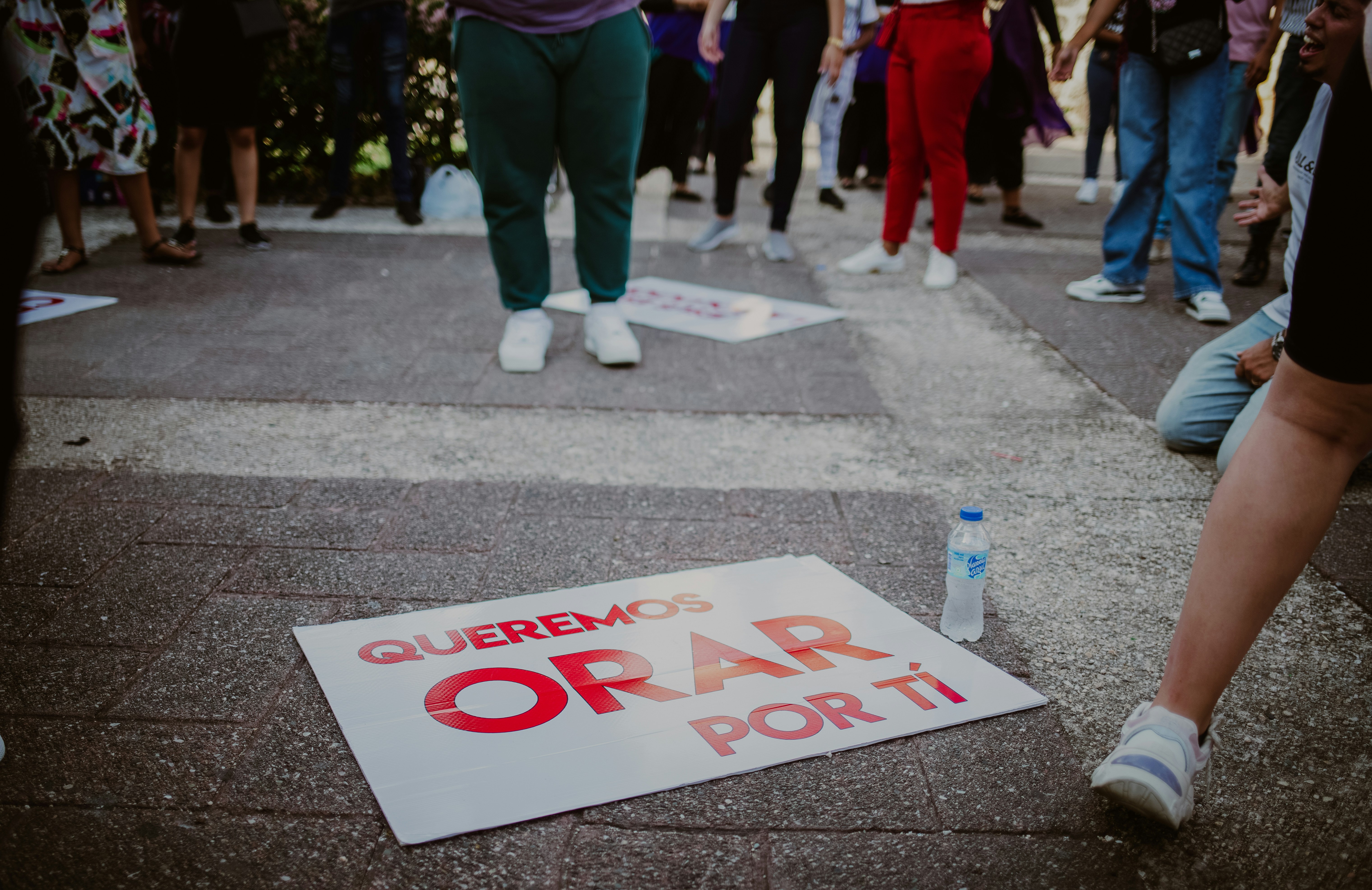 a group of people standing around a sign on the ground