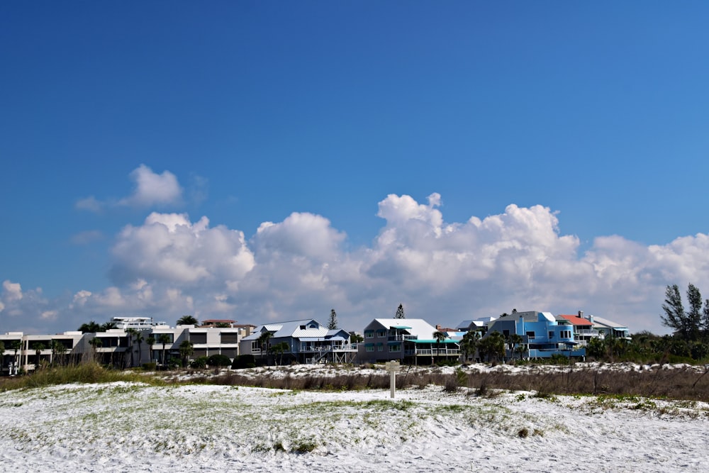 a row of houses sitting on top of a sandy beach