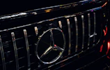 Close-up of a polished chrome grille and emblem on a luxury sports car.