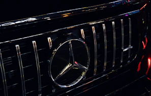 Close-up of a polished chrome grille and emblem on a luxury sports car.