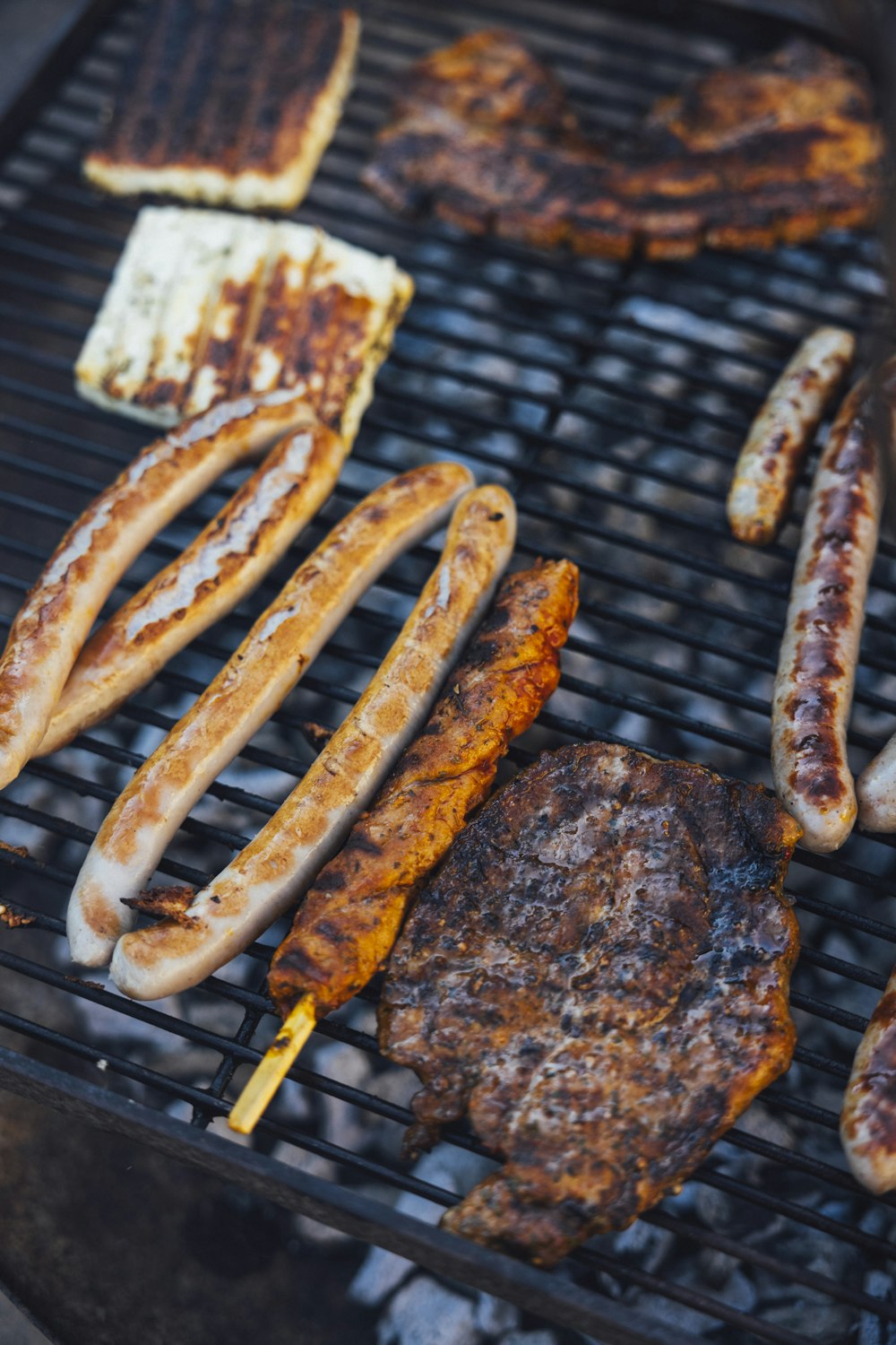 a grill with several sausages and hot dogs cooking on it