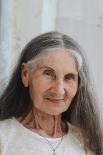 A softly lit photo of Nancy Ellen Long Guthrie smiling gently, framed by desert gold and sage green hues.