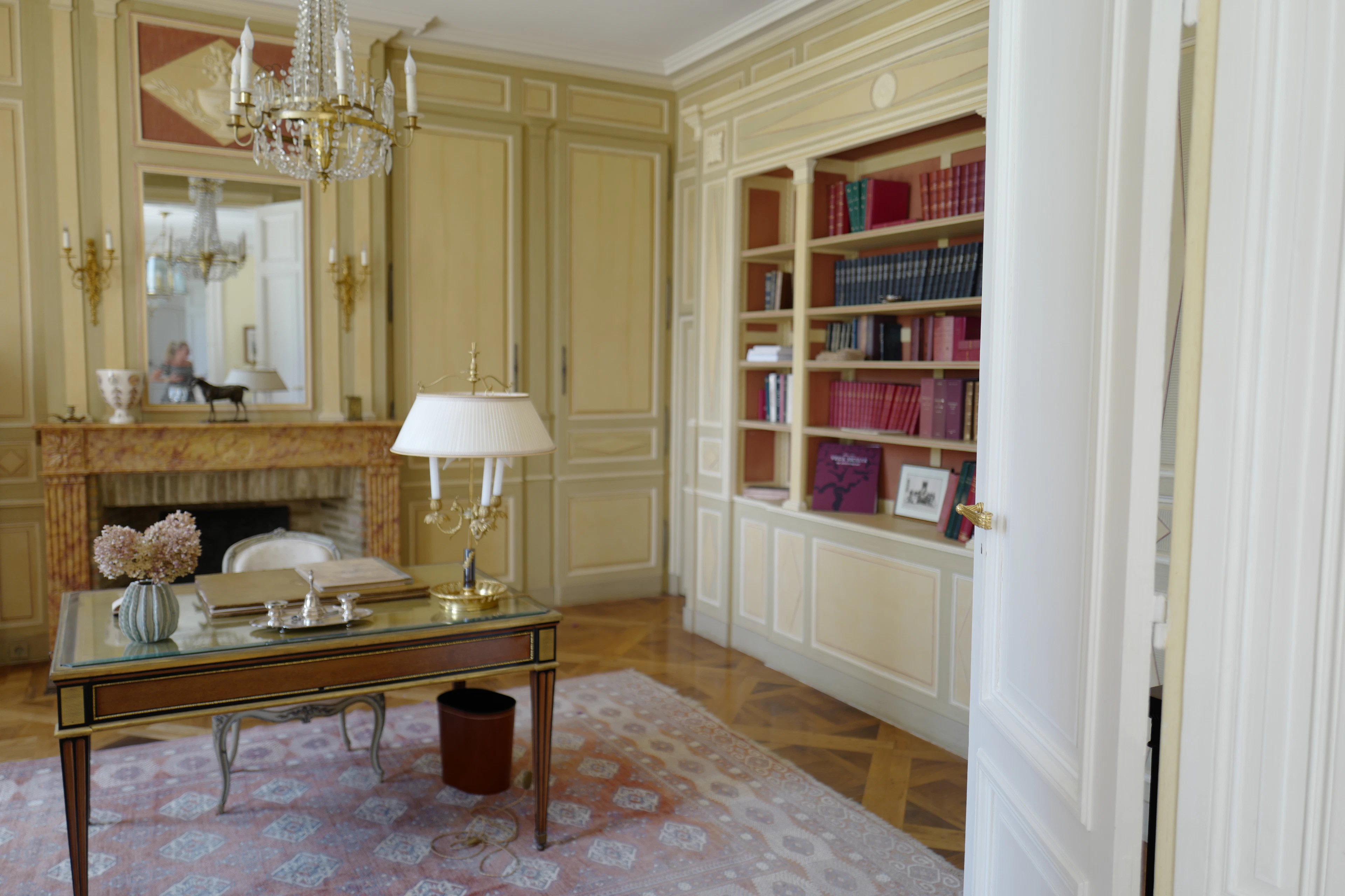 Salon parisien avec bibliothèque et cheminée