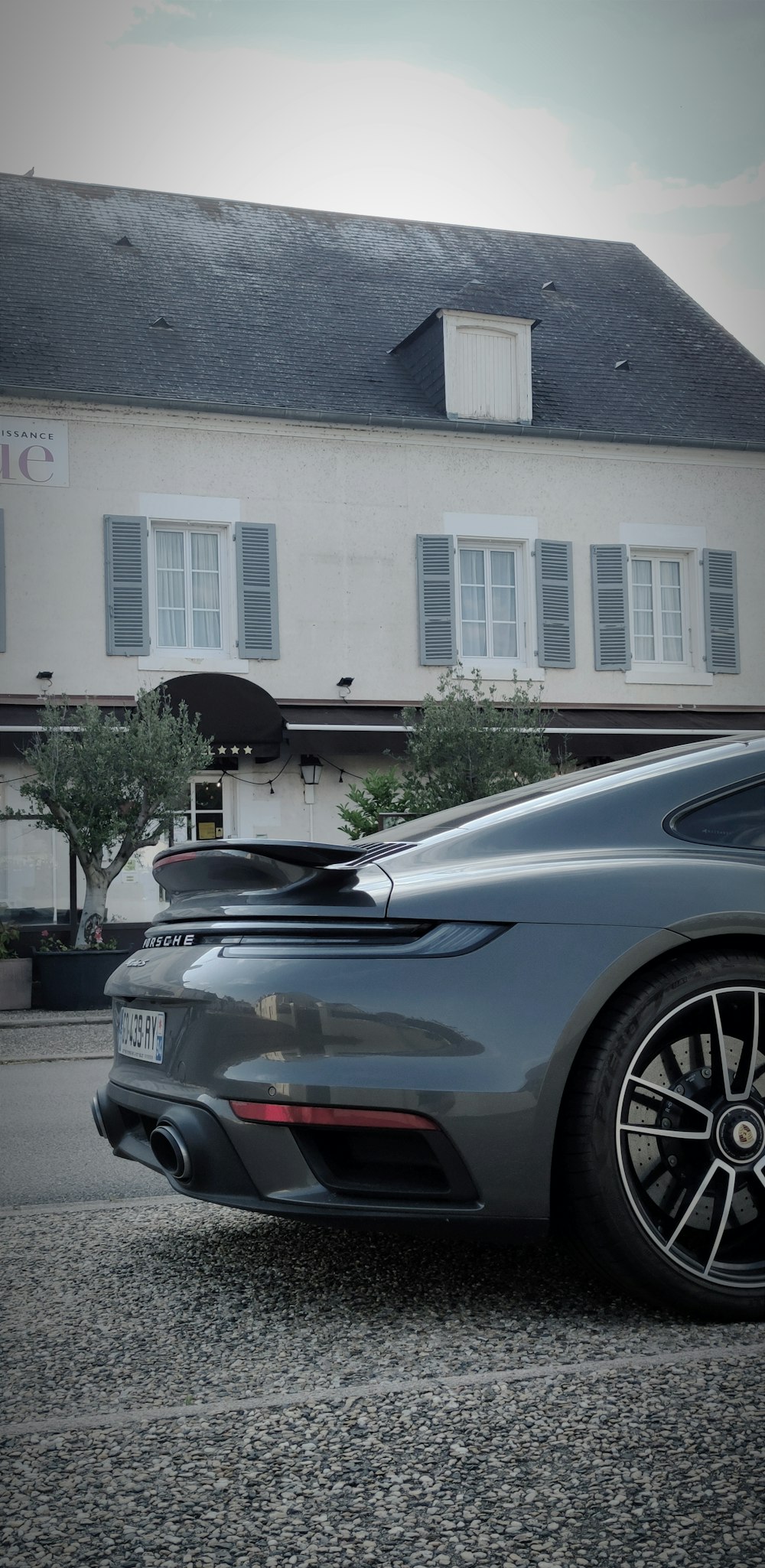 a grey sports car parked in front of a building