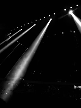 a black and white photo of three spotlights in the dark