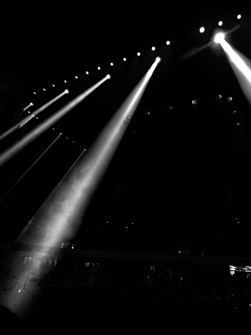 a black and white photo of three spotlights in the dark