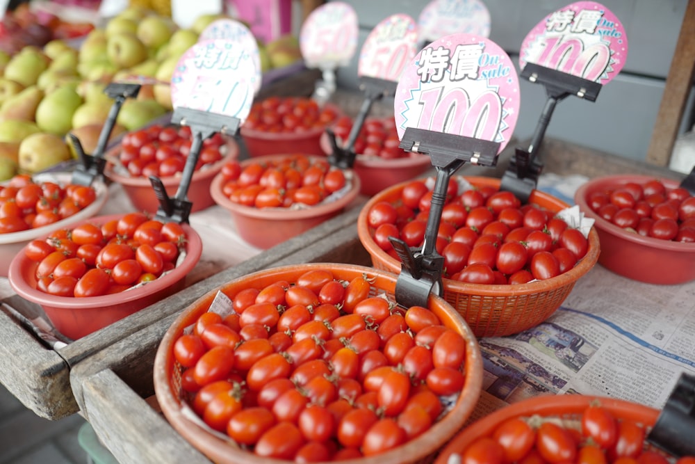 a table topped with bowls filled with lots of tomatoes