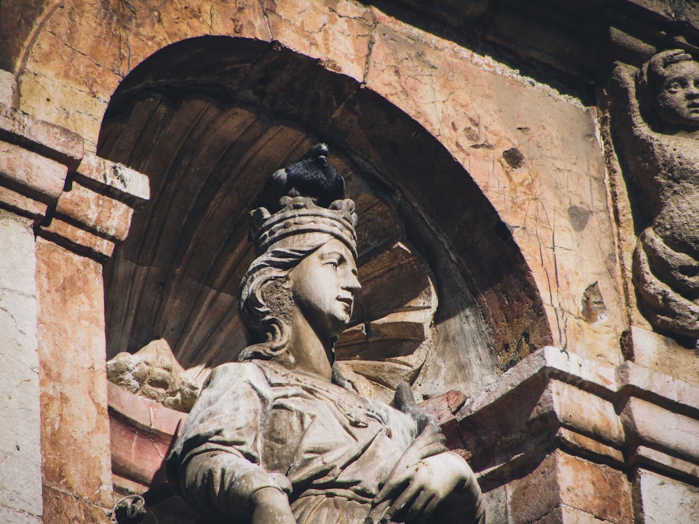 una statua di una donna con un uccello sulla testa