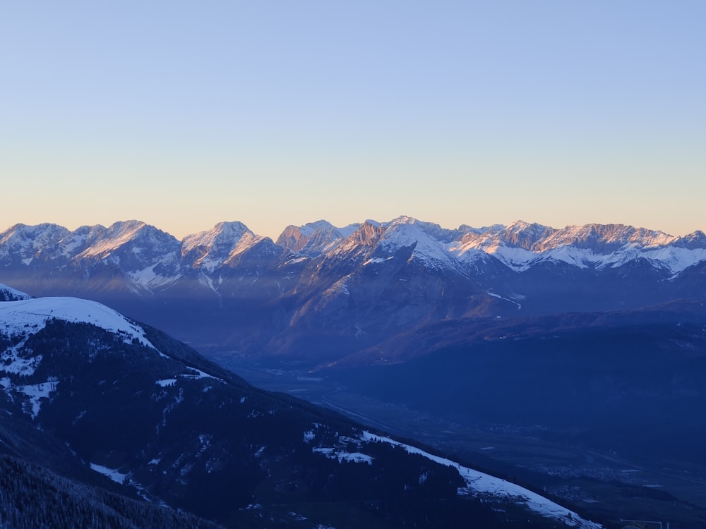 a mountain range with snow covered mountains in the background