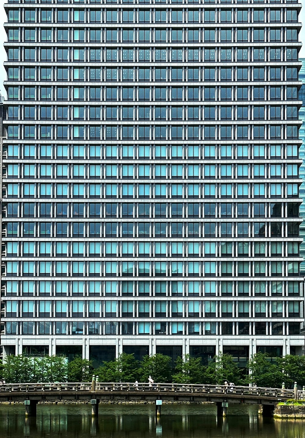 a very tall building with lots of windows next to a body of water