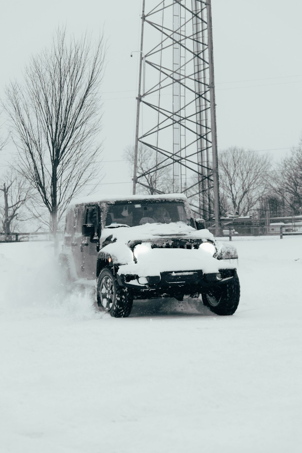 a truck driving through a snow covered field