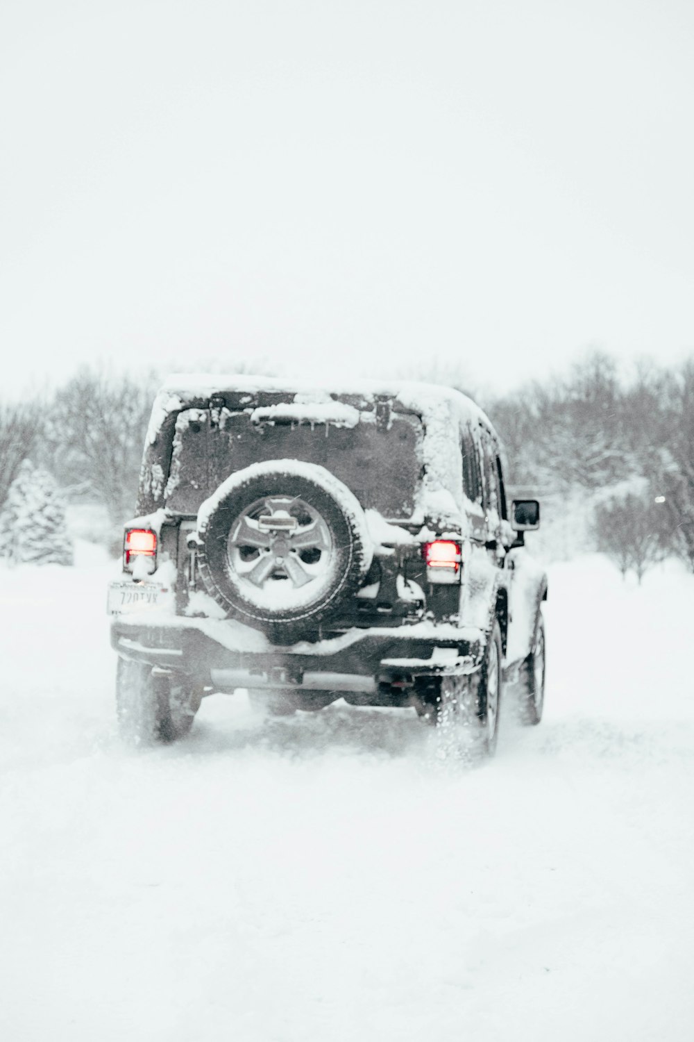 a jeep driving down a snow covered road