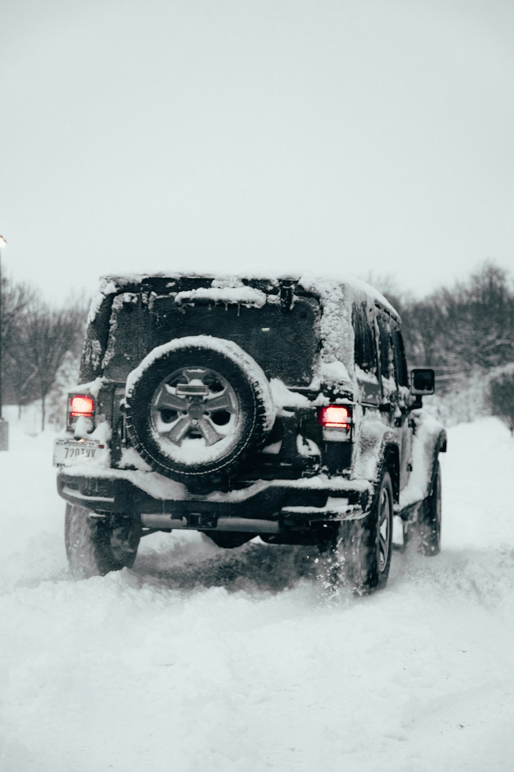 a jeep driving down a snow covered road
