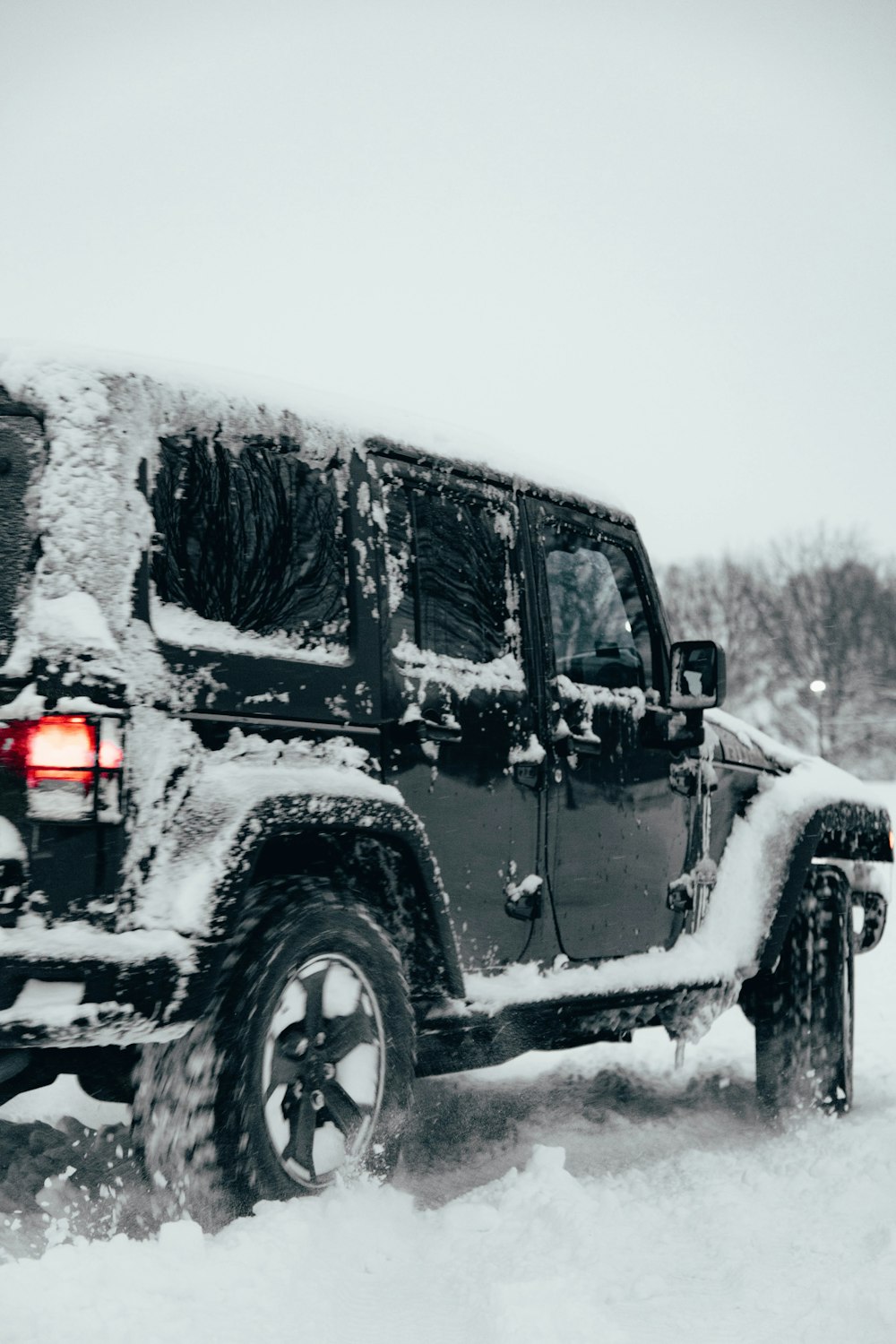 a jeep is covered in snow on a snowy day