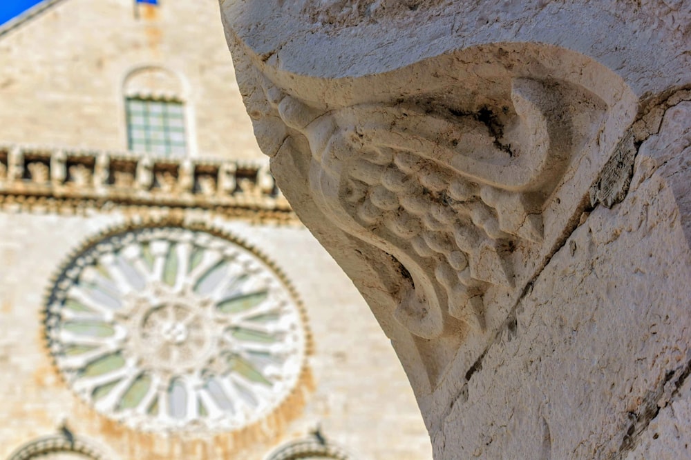 a close up of a statue with a clock in the background