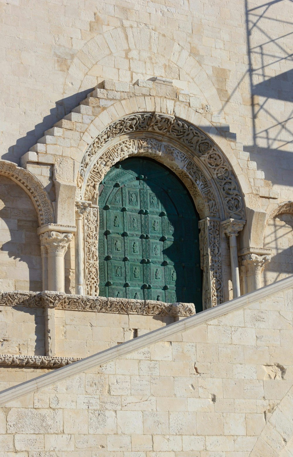 a stone building with a large green door