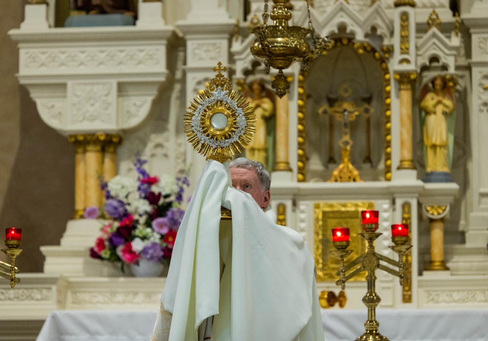 a man in a priest's robes holding a cross