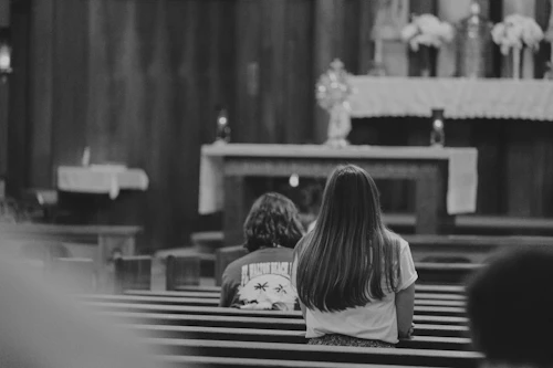 catholic online dating – couple talking quietly in a church pew