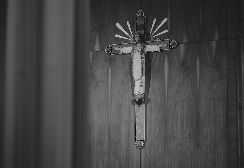 a black and white photo of a cross on a wall
