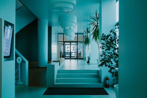 A modern cleanroom interior with bright lighting and green plants visible through glass walls.