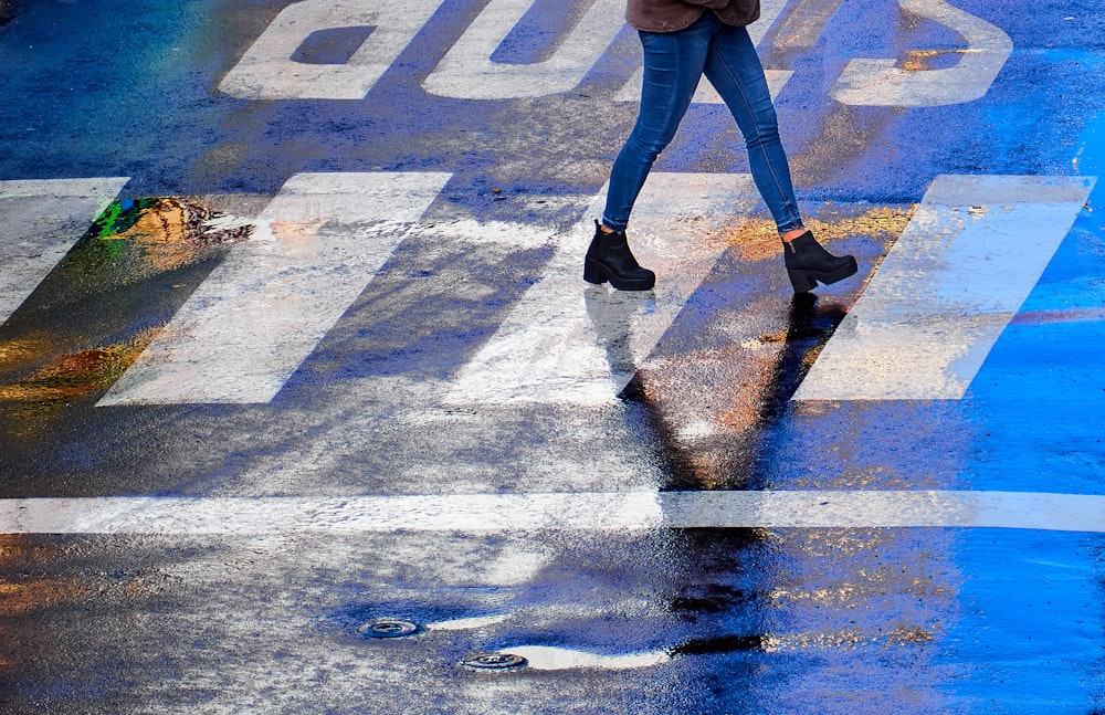 a woman crossing the street in the rain