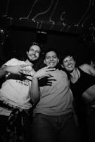 Smiling friends posing together, their images captured in crisp black and white by the booth.