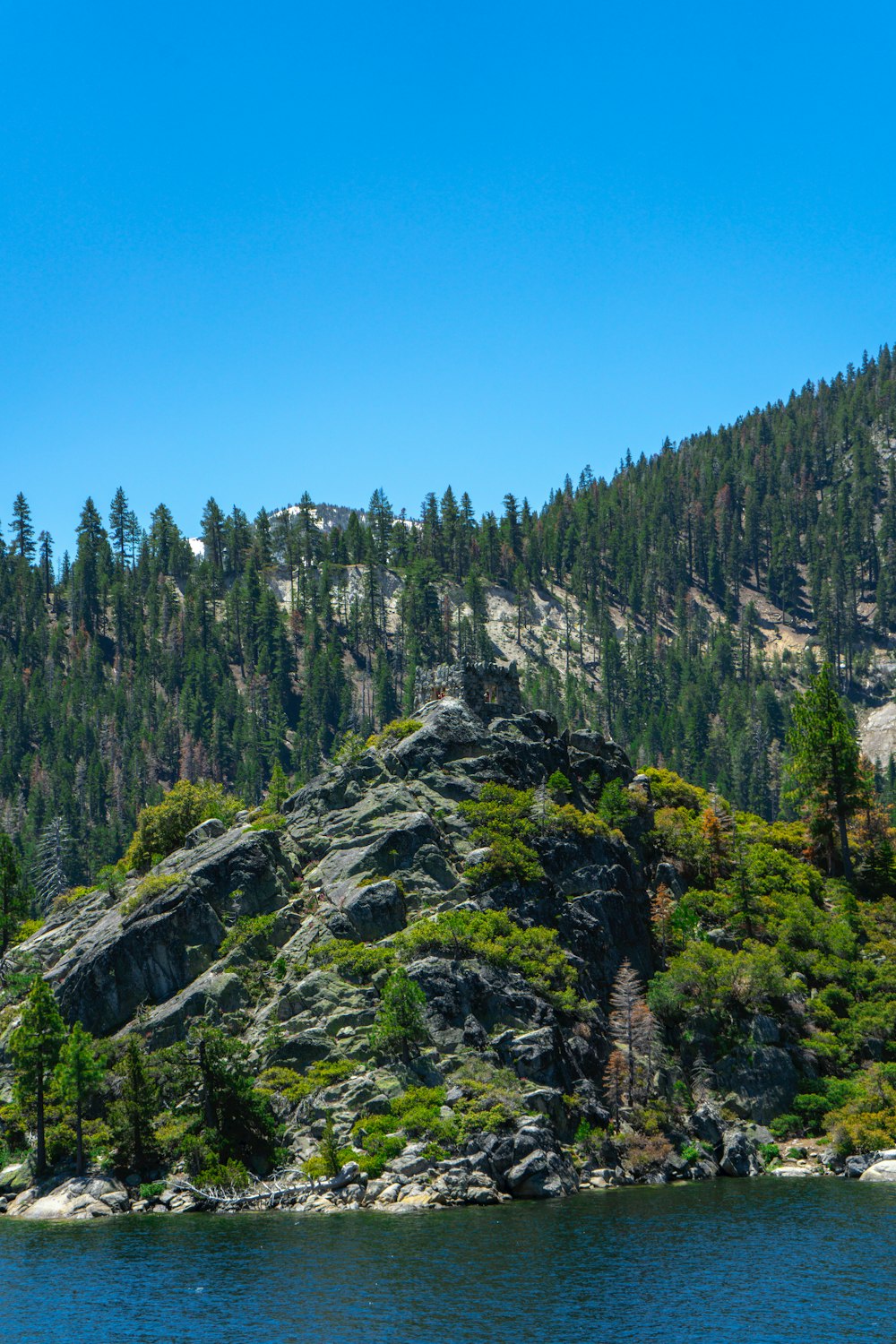 a boat is on the water in front of a mountain