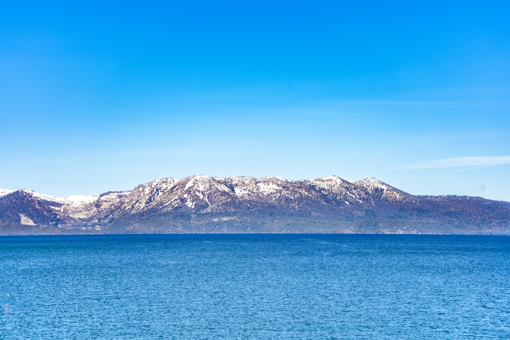 a large body of water with mountains in the background