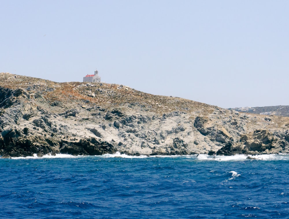 a lighthouse on top of a rocky outcropping in the ocean